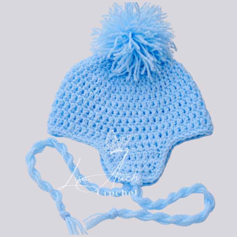 Light blue knitted baby hat with a fluffy pom-pom and braided tassel ties extend from the sides.