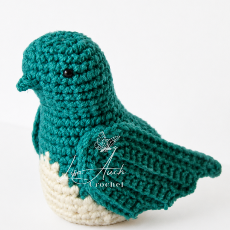 crochet bird pattern amigurumi bird with a cream belly, facing left, black eye visible.